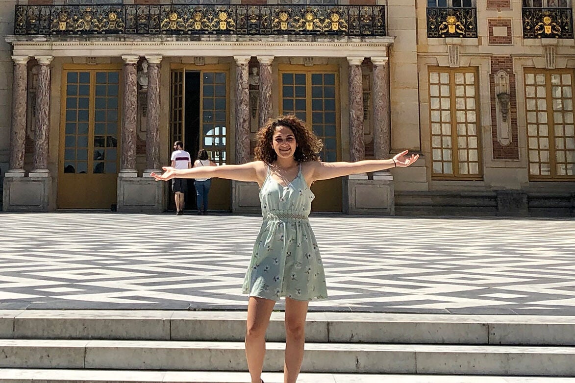 Jackie poses in front of the Château de Versailles in Paris, France