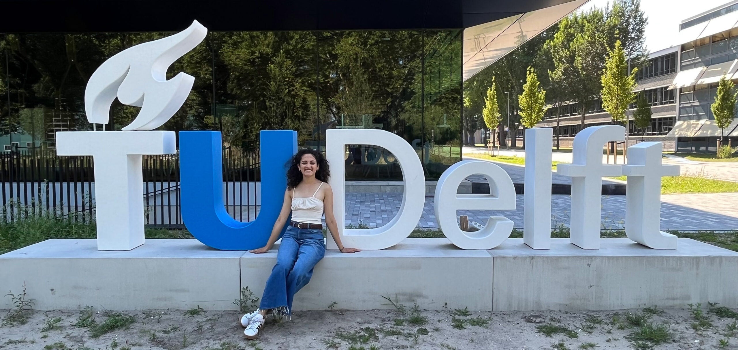 Villalobos poses in front of the TU Delft sign