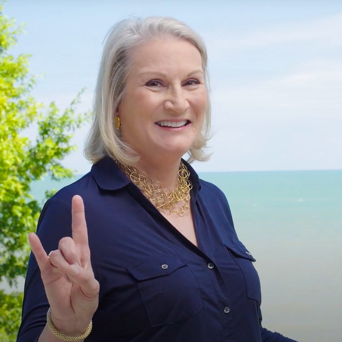 Connie Duckworth poses in front of an ocean a shows off her Longhorn pride